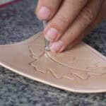 Using a bevelling tool to begin tooling a leather design